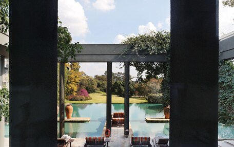 A view of a pool area with lounge chairs and a pergola structure.