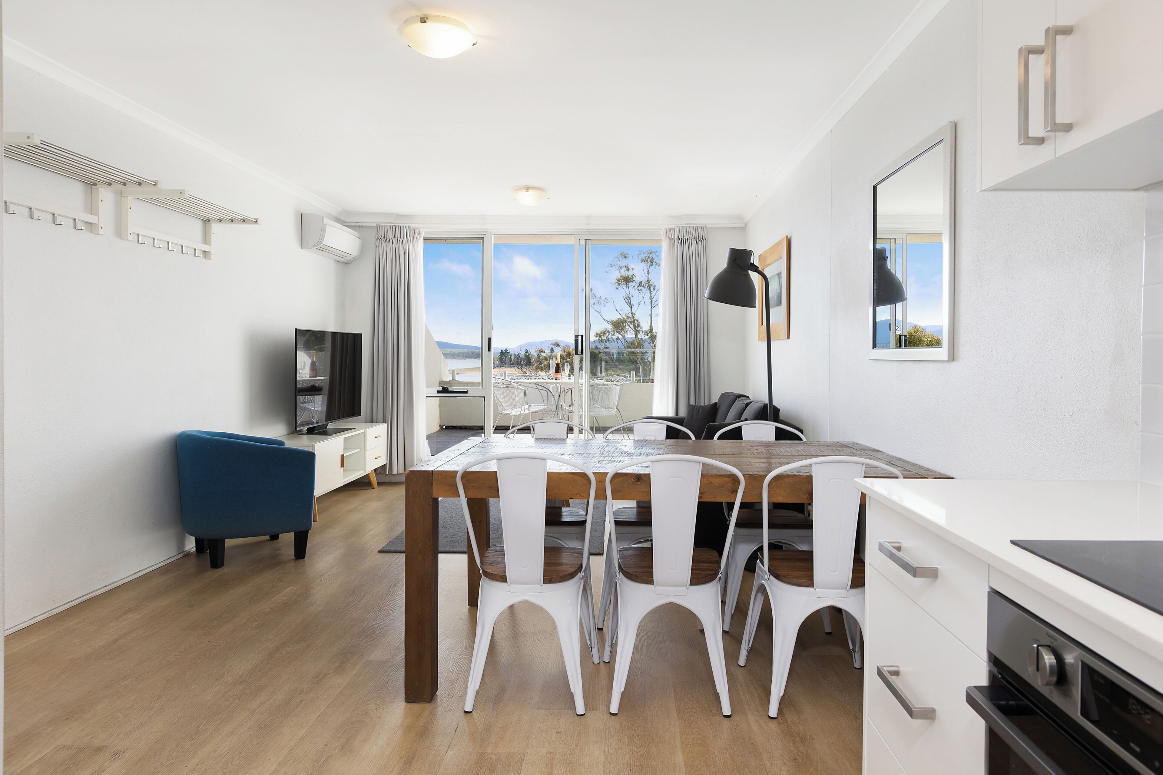 Una cocina moderna con comedor, televisor y vistas al exterior.