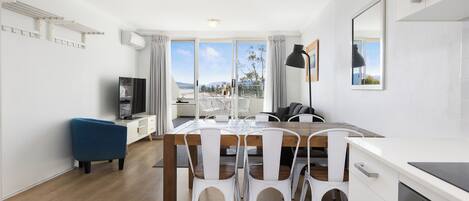 Una cocina moderna con comedor, televisor y vistas al exterior.
