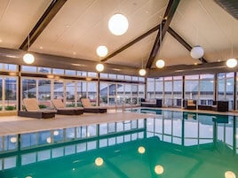 Una piscina techada, sillones reclinables de piscina