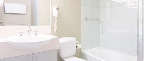 Un baño con lavamanos, inodoro y ducha.
