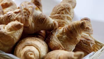 Una cesta llena de diferentes tipos de croissants.