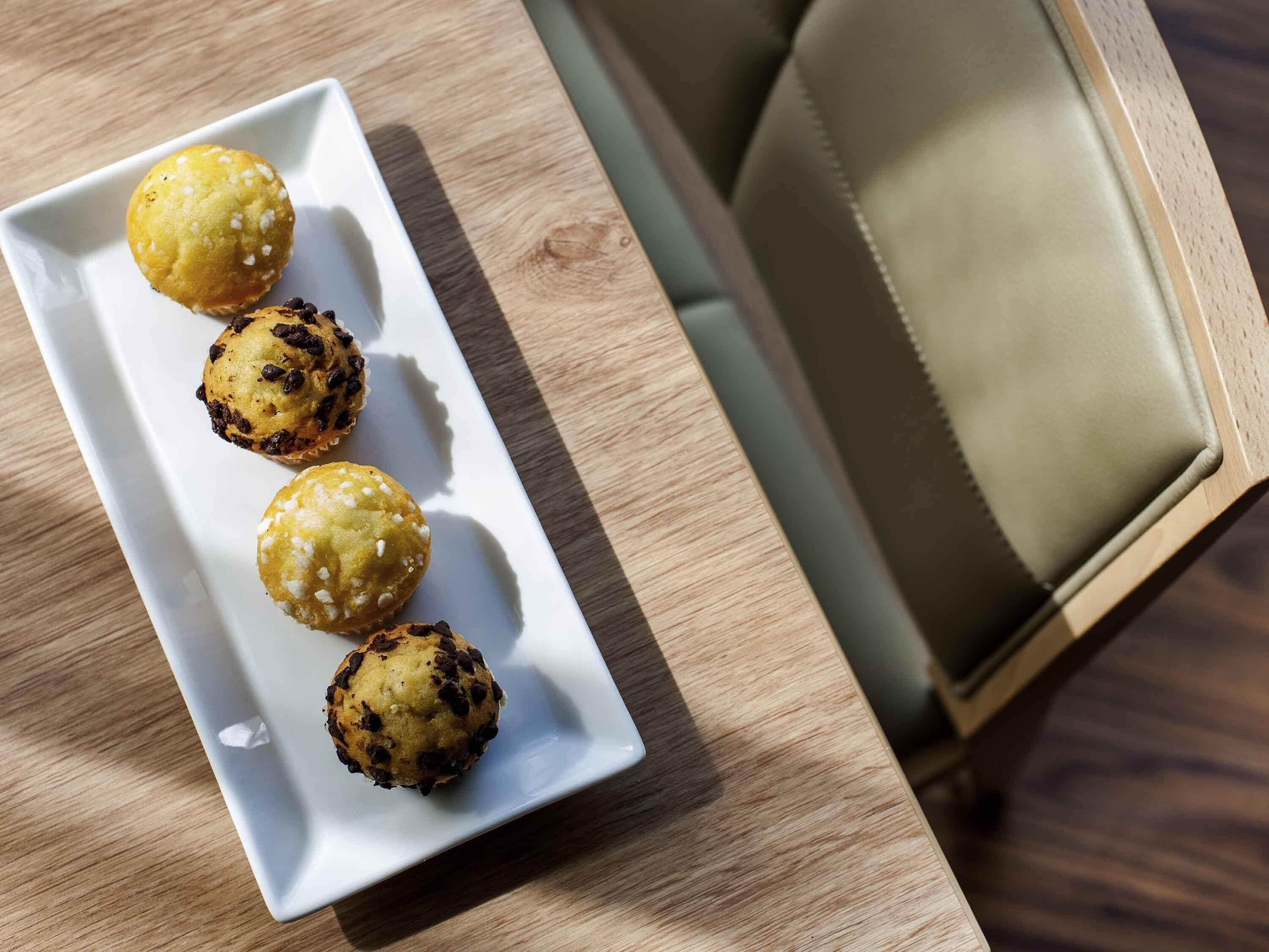 A white rectangular plate with four round pastries on a wooden table.