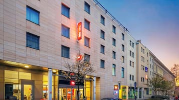 A hotel with a modern facade, multiple windows, and a visible entrance.