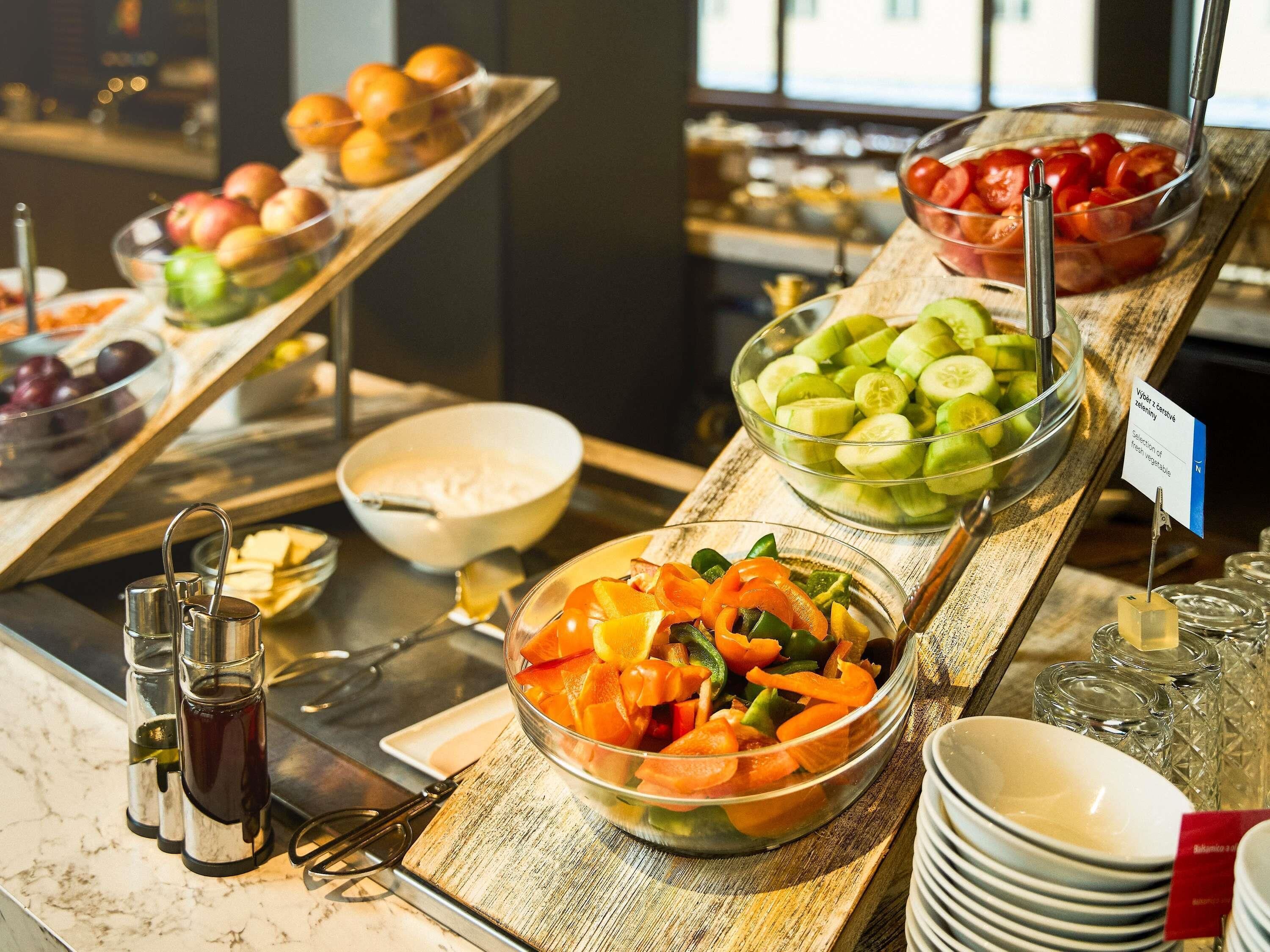 A buffet with various food options including fruits, vegetables, and a selection of cheeses.