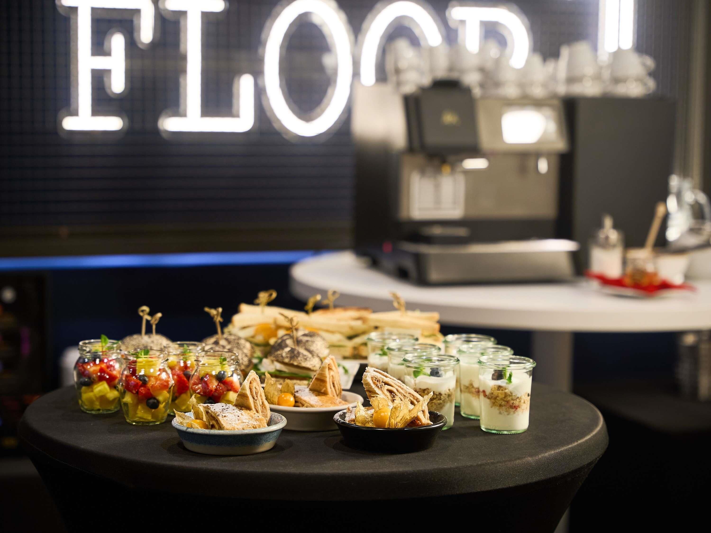 A food display with various dishes and a coffee machine in the background.