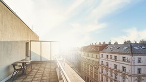 Un balcón con mesa y sillas, con vistas a una hilera de edificios históricos.