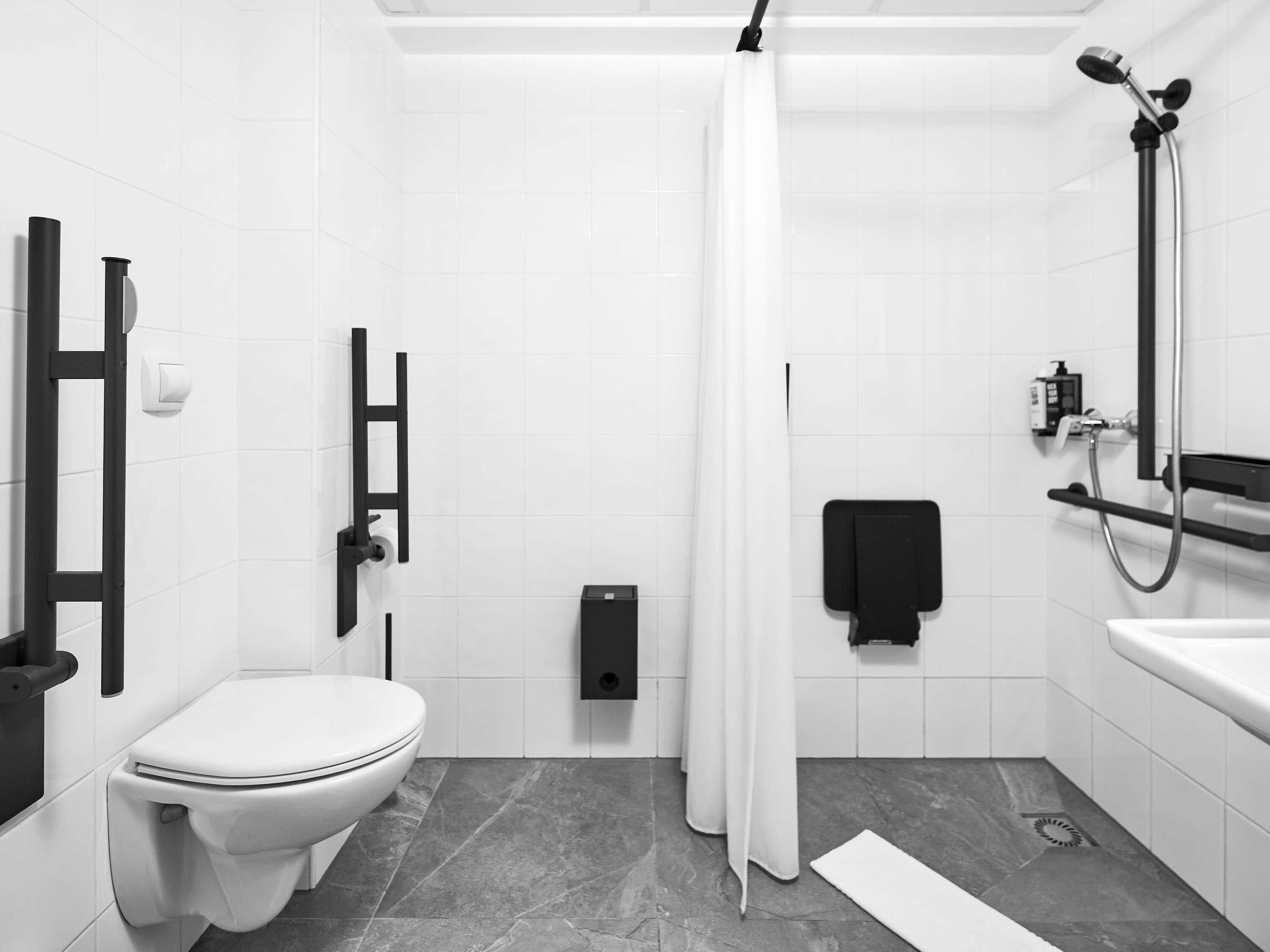 A modern bathroom with a toilet, shower, and sink.