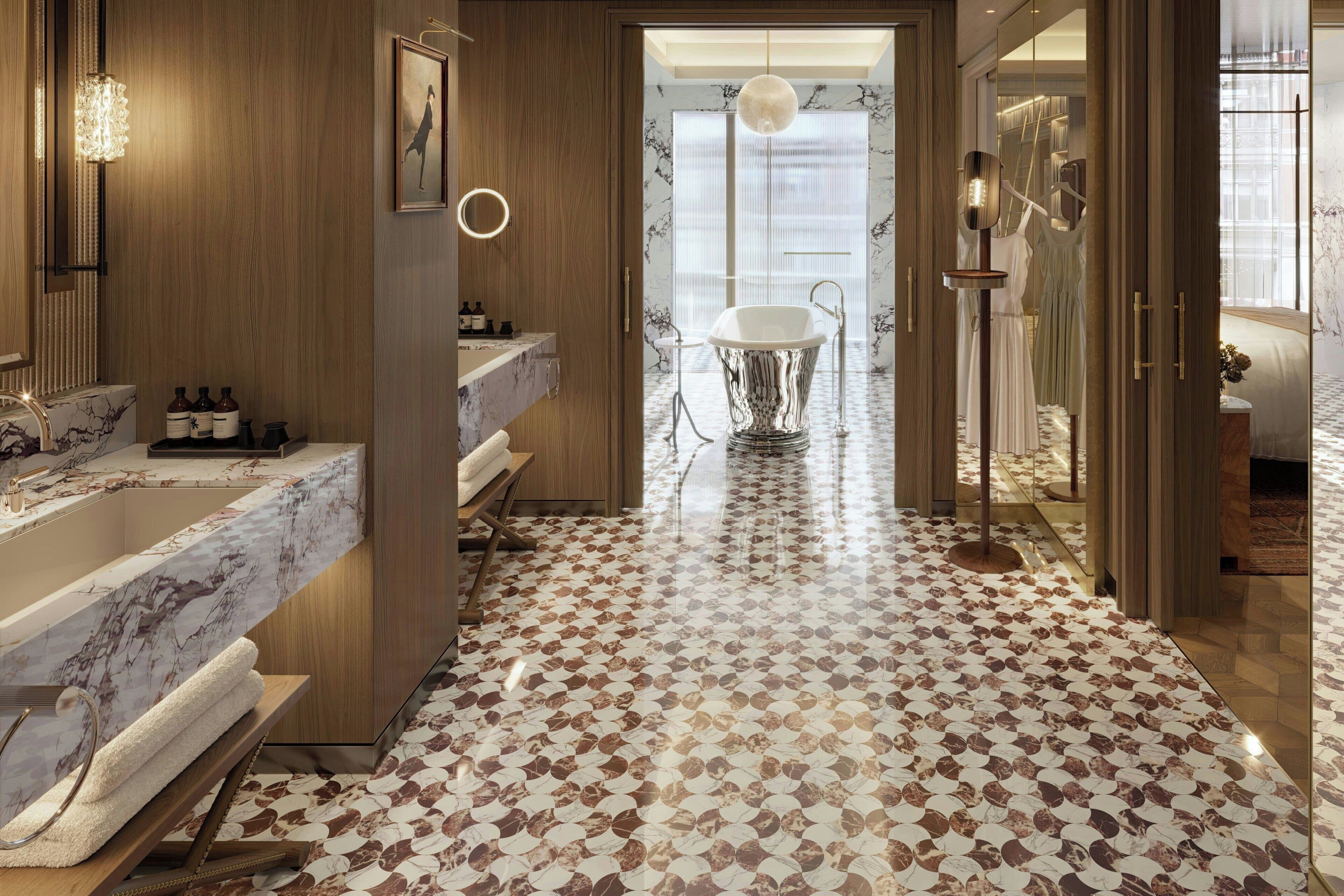 A modern bathroom with a marble sink, a bathtub, and a patterned floor.