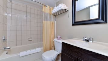 A bathroom with a bathtub, toilet, and sink.