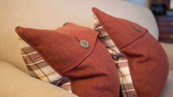 A plush toy shaped like an elephant with a plaid pattern and a button detail.