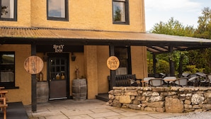 Una posada en Spey con terraza exterior y pared de piedra.