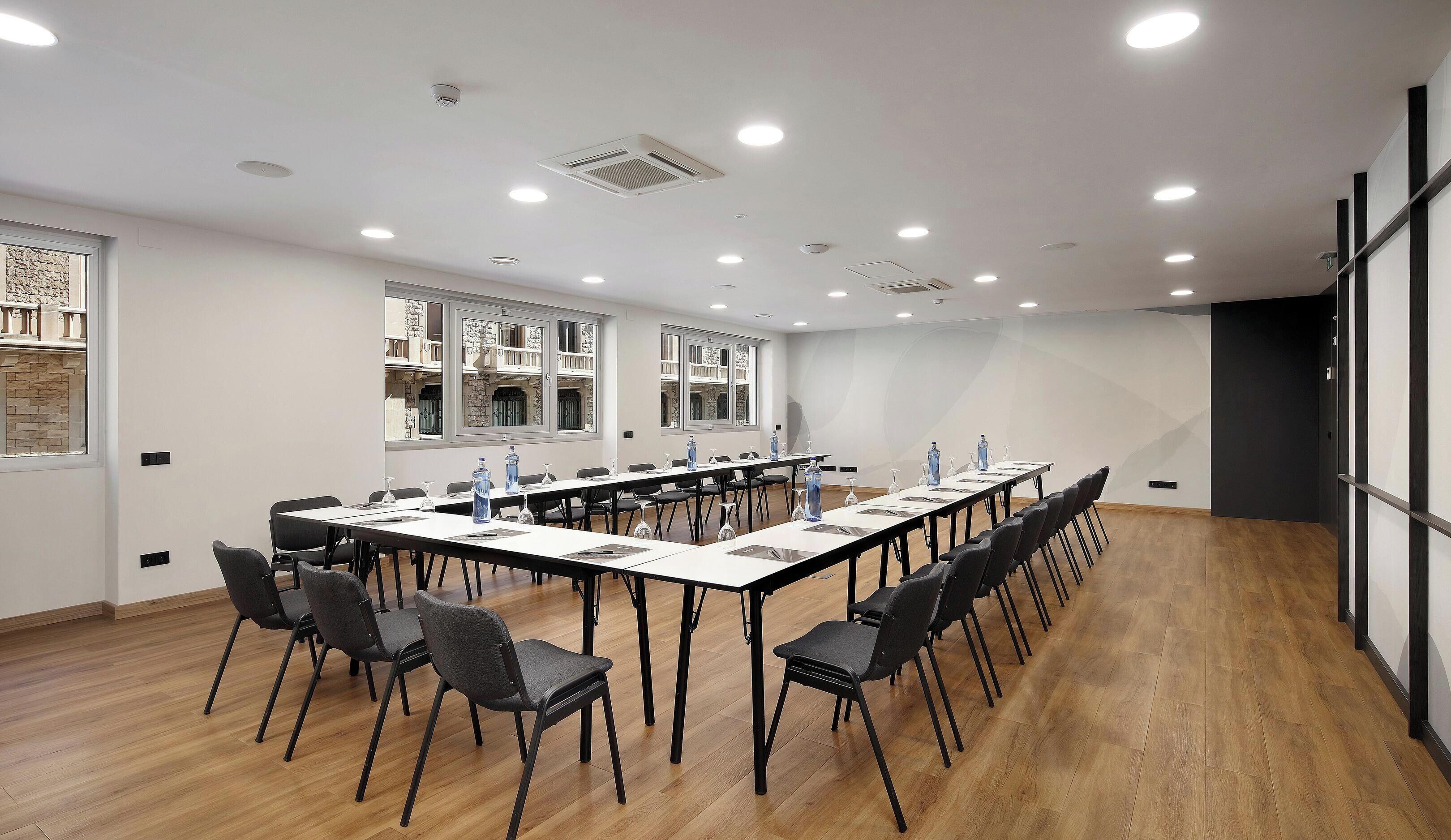 Une salle de conférence dotée d’une longue table, de chaises et de fenêtres donnant sur des balcons.