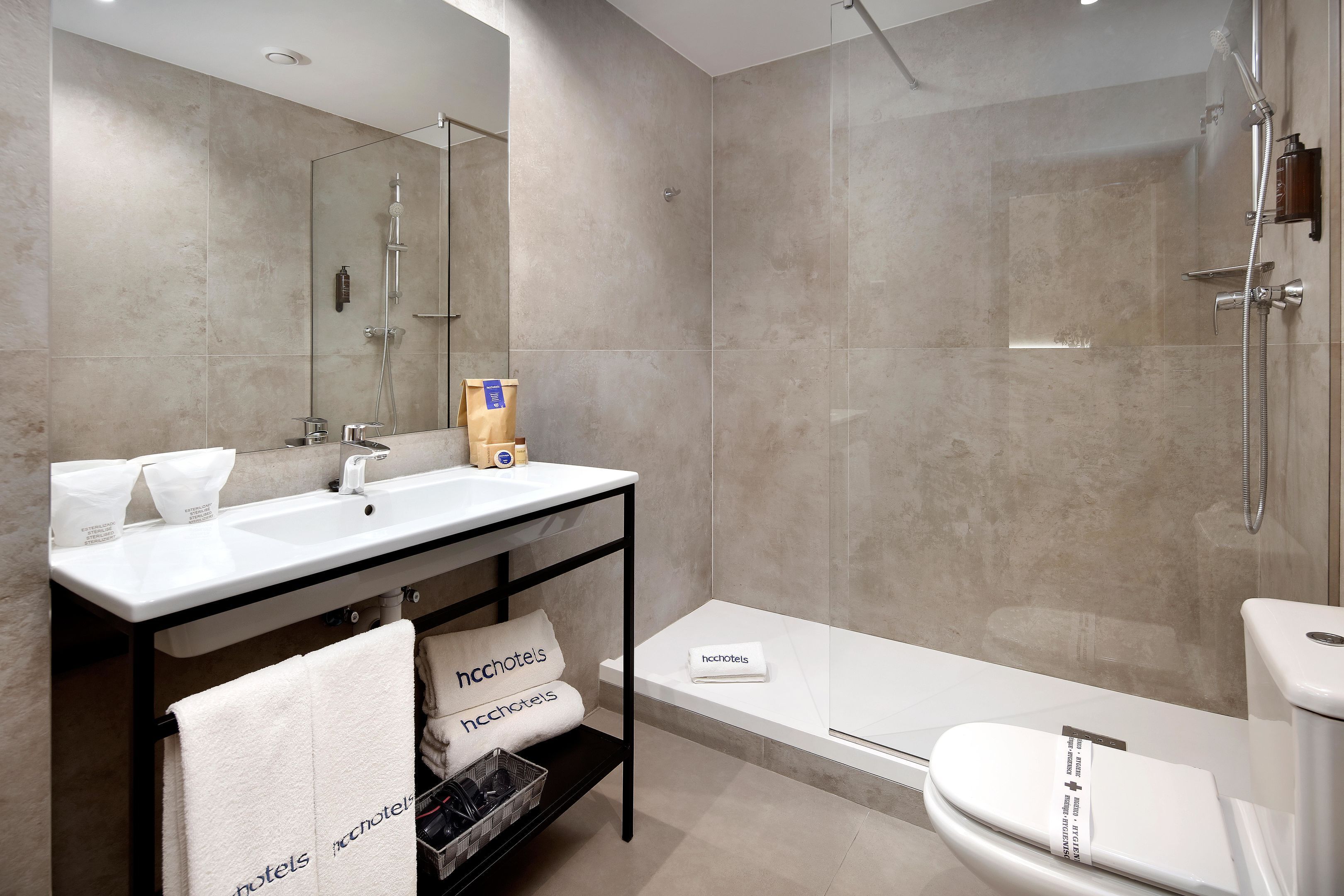 Een moderne badkamer met een grote spiegel, een wastafel, een badkuip en een douche.