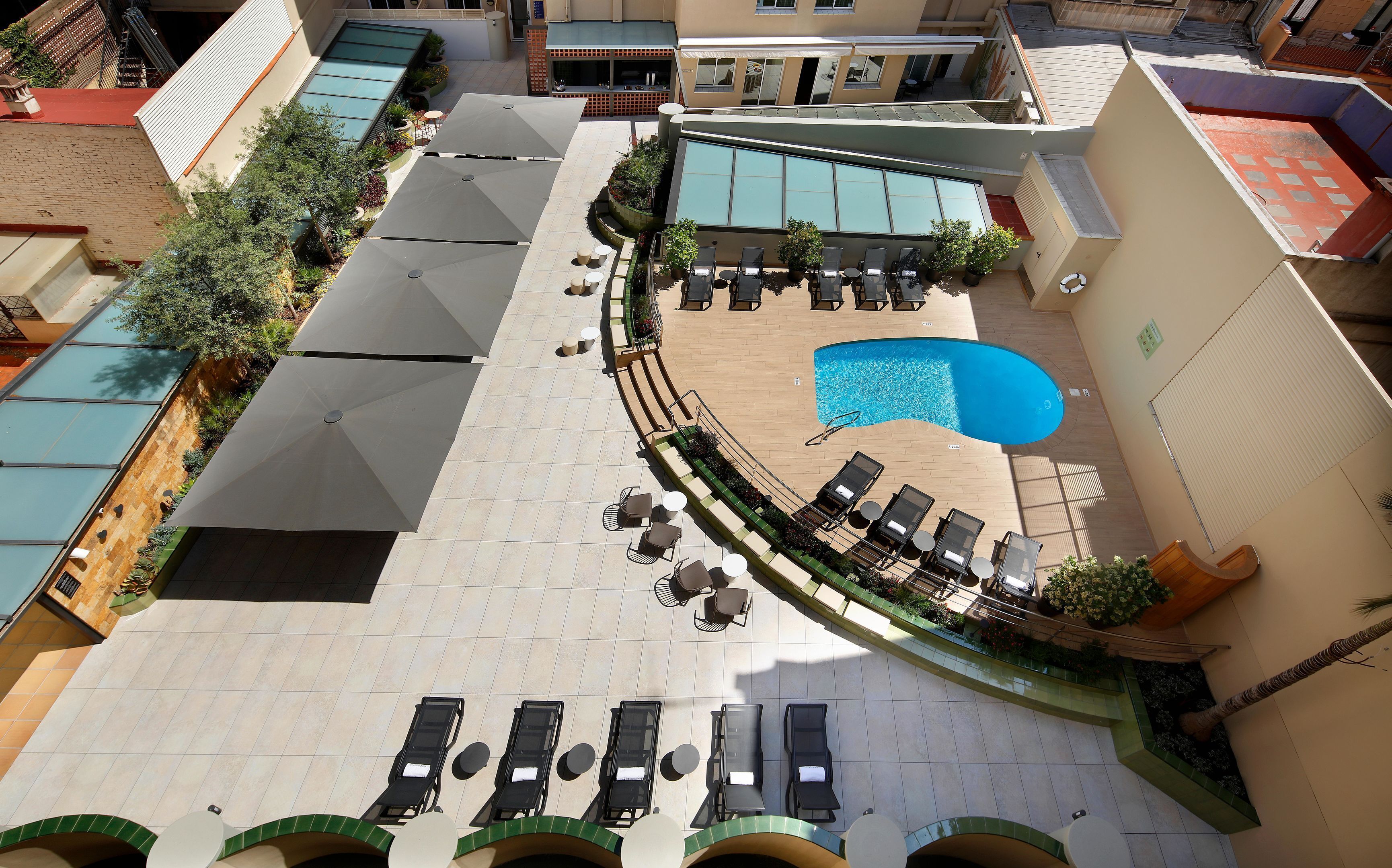 A rooftop pool area with sun loungers and a small swimming pool.