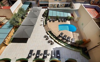 A rooftop pool area with sun loungers and a small swimming pool.