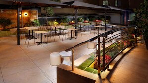 An outdoor patio area with tables and chairs, a staircase, and a railing. - Hotel HCC MontBlanc (Barcelona)