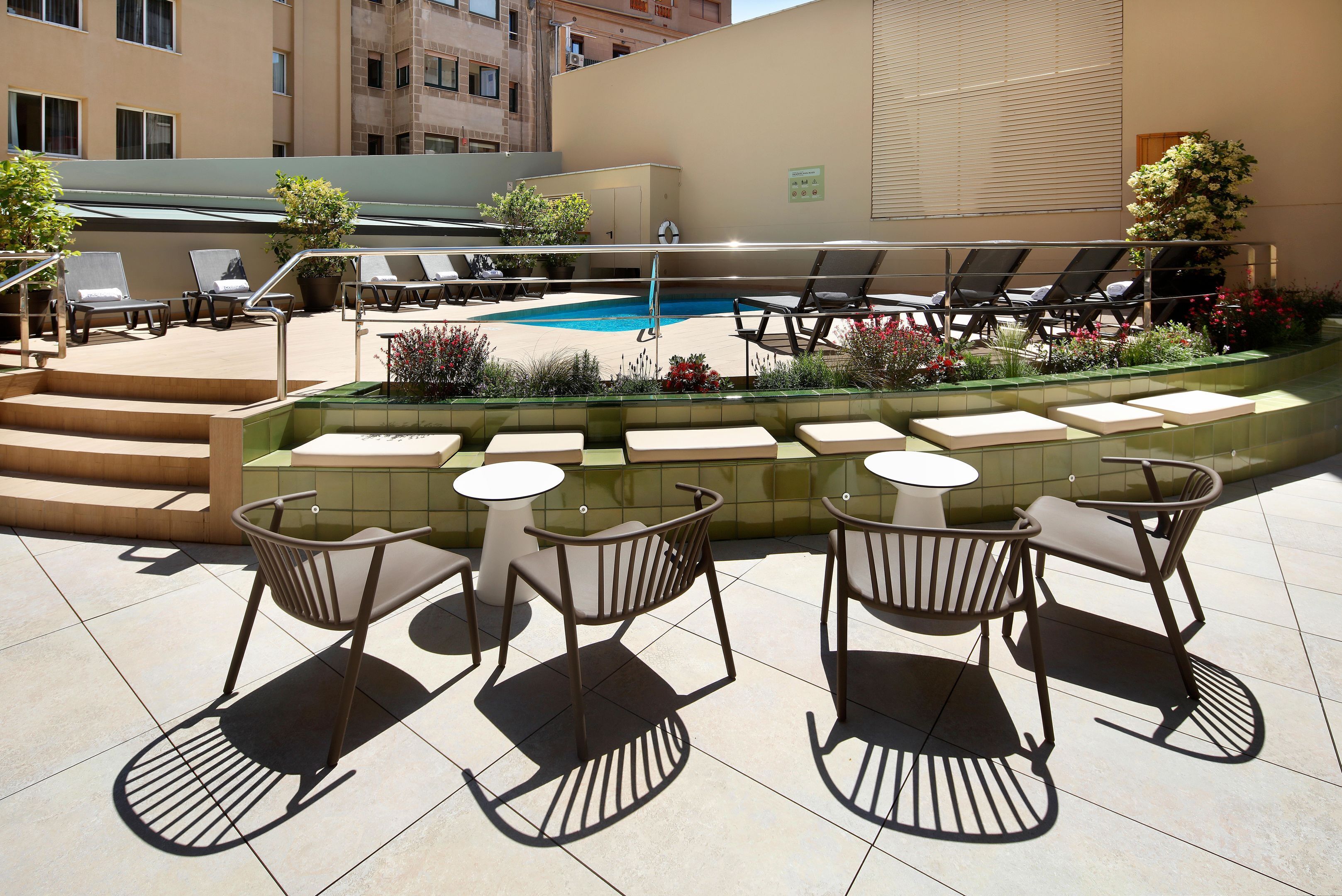 Un espace piscine aménagé sur le toit, avec des chaises longues et une petite table.