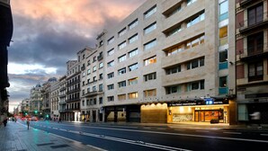 A hotel with multiple floors, a prominent entrance, and a parking area. - Hotel HCC MontBlanc (Barcelona)