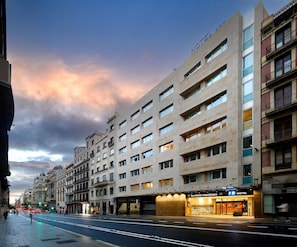 A hotel with multiple floors, a prominent entrance, and a parking area. - Hotel HCC MontBlanc (Barcelona)