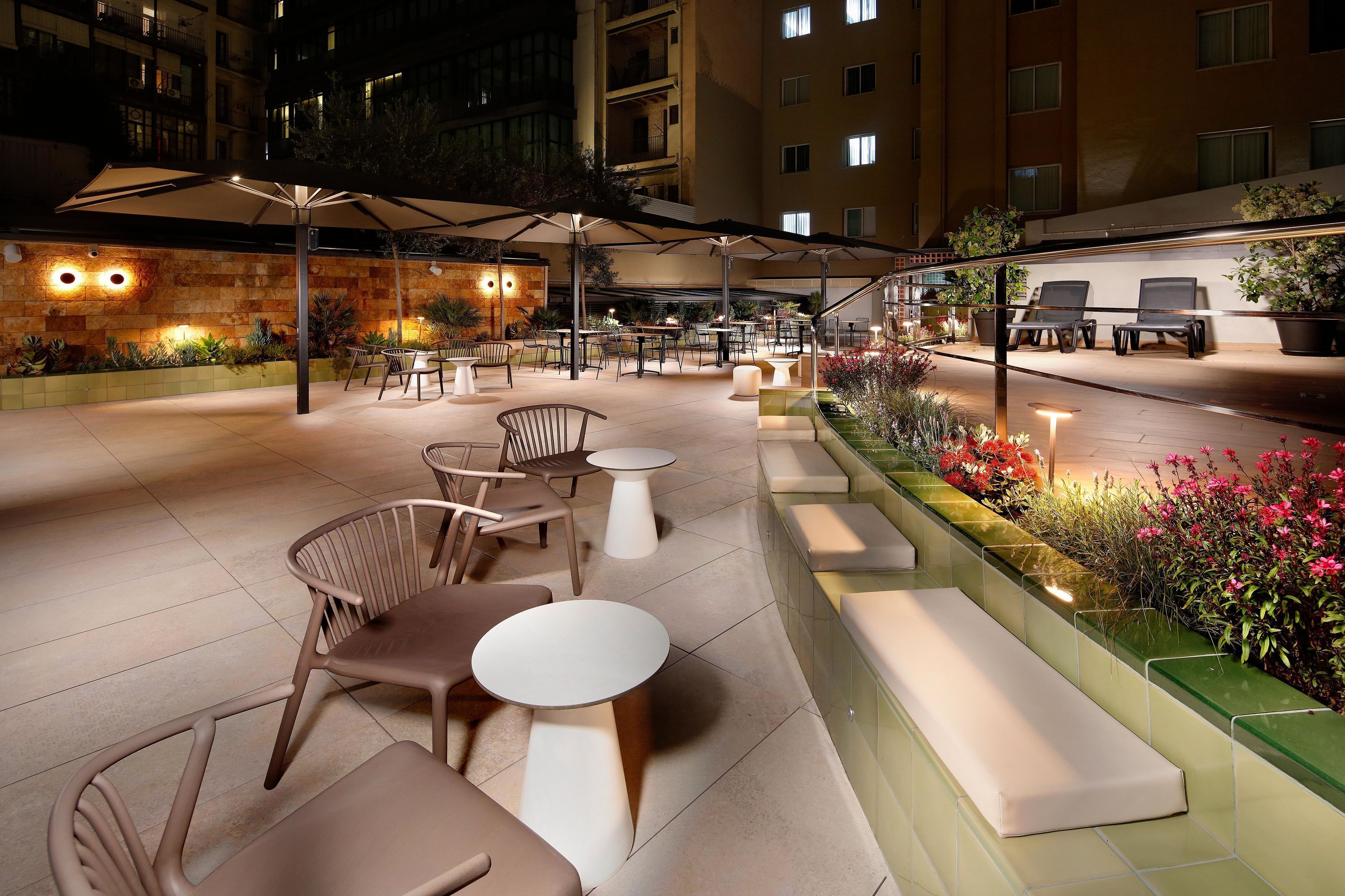 An outdoor patio area with seating, tables, and umbrellas.