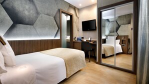 A modern hotel room with a bed, desk, and a large mirror. - Hotel HCC MontBlanc (Barcelona)