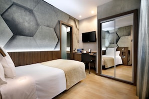 A modern hotel room with a bed, desk, and a large mirror. - Hotel HCC MontBlanc (Barcelona)