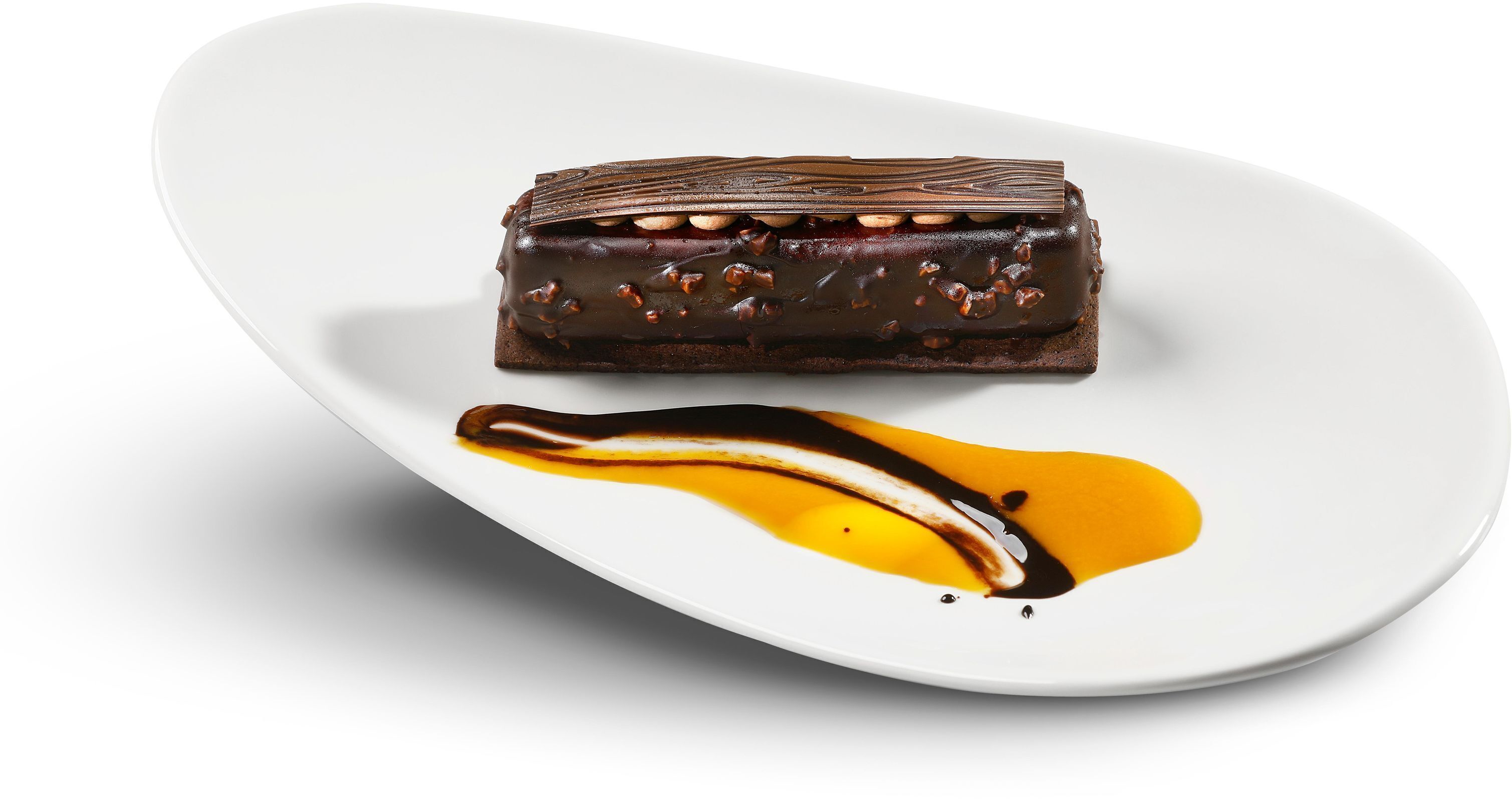 A dessert on a white plate with a chocolate glaze and nuts.