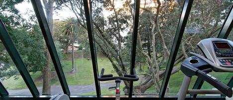 A stationary bike in a room with large windows.