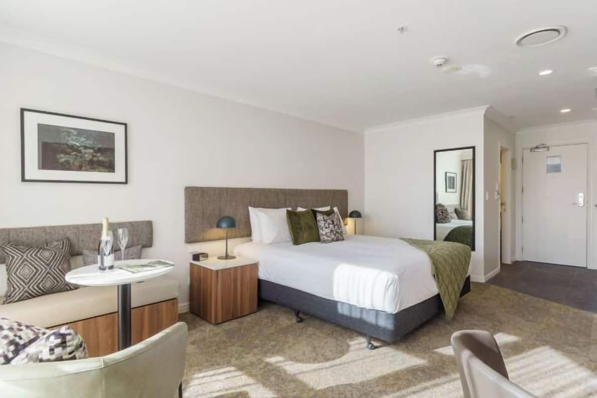 Relax in a stylish room with a large bed, sofa, and elegant touches.