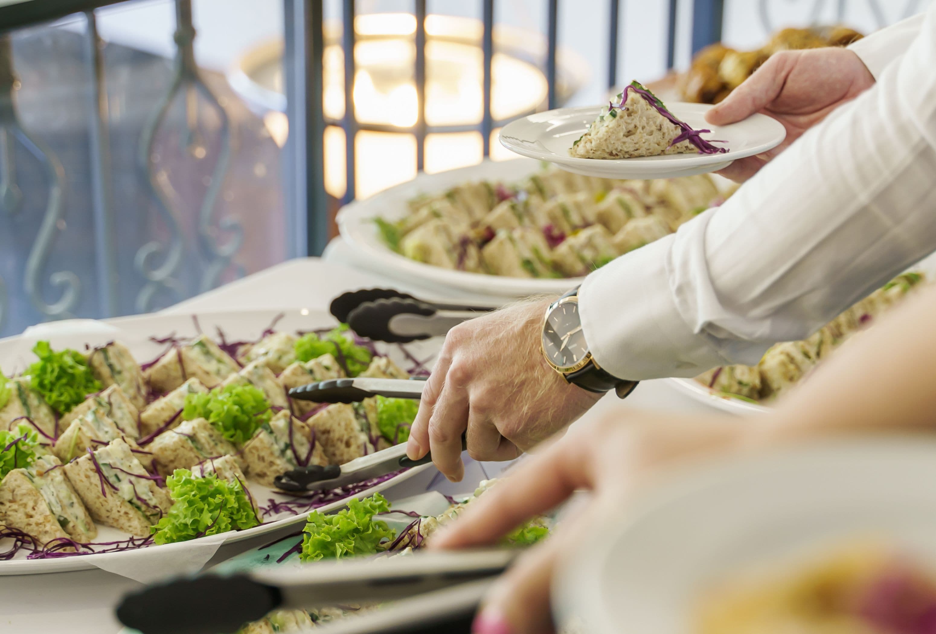 Een eettafel met verschillende gerechten, waaronder een salade en een belegd broodje.