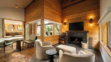 A modern interior with wooden walls, a fireplace, and a dining area with a round table and chairs.