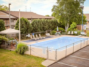 Una piscina al aire libre de temporada, sombrillas, tumbonas