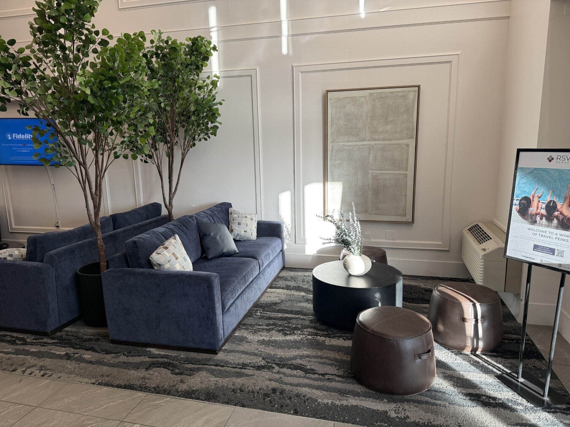 A modern living room with a sectional sofa, a coffee table, and a potted plant.