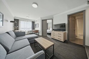 Suite Standard, 1 letto queen con divano letto, angolo cottura | Area soggiorno | TV, film pay-per-view