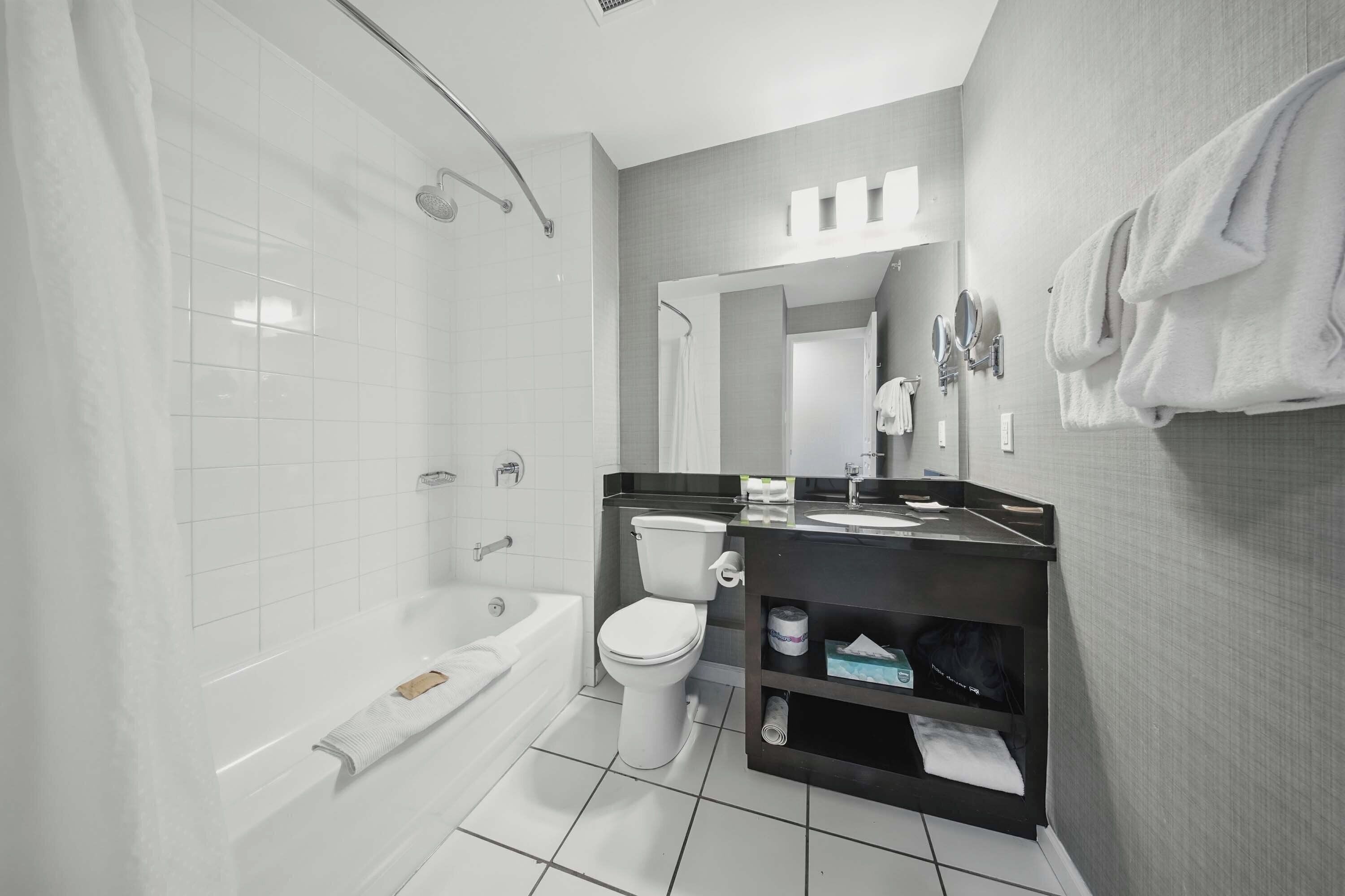 A modern bathroom with a bathtub, toilet, and sink.