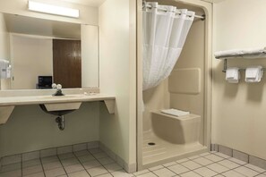 A bathroom with a sink, mirror, shower, and towel rack. - Super 8 by Wyndham North Bay (North Bay)