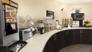 Una barra de desayuno con una plancha para gofres, un tostador y una cafetera.