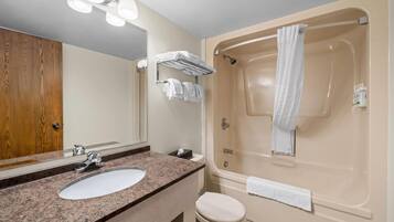 Une salle de bain équipée d’un lavabo, d’un miroir, d’un porte-serviettes et d’une baignoire.