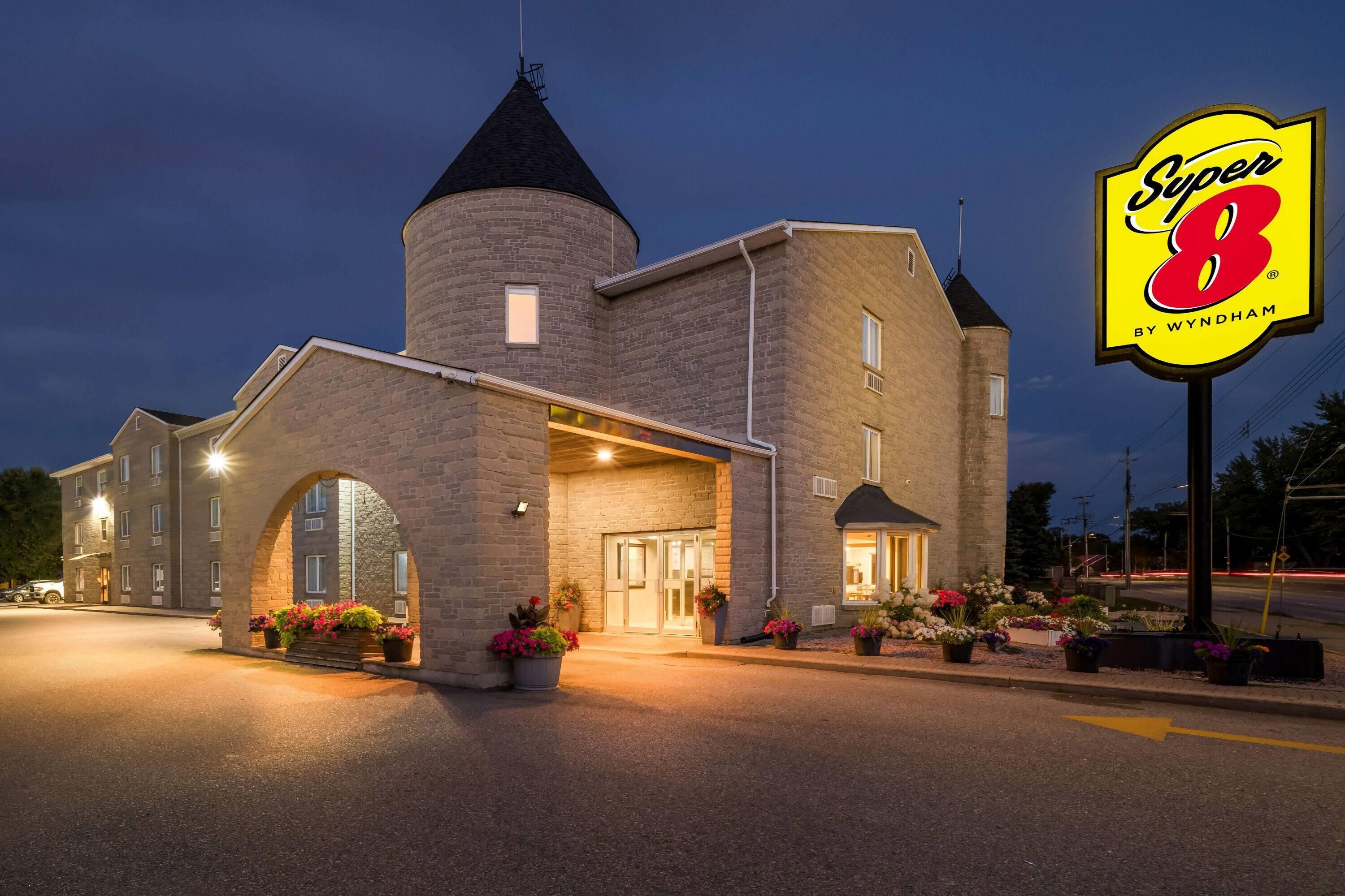 A hotel with a stone facade, a central tower, and a sign for 'Super 8 by Wyndham'.