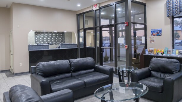 A reception area with leather sofas, a glass coffee table, and a reception desk.