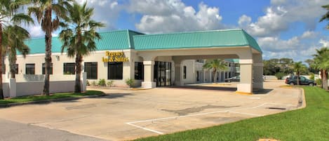A building with a green roof and a sign reading "Emergency Inn & Suites".