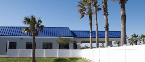A building with a blue roof and a sign that reads "Regency Inn & Suites".