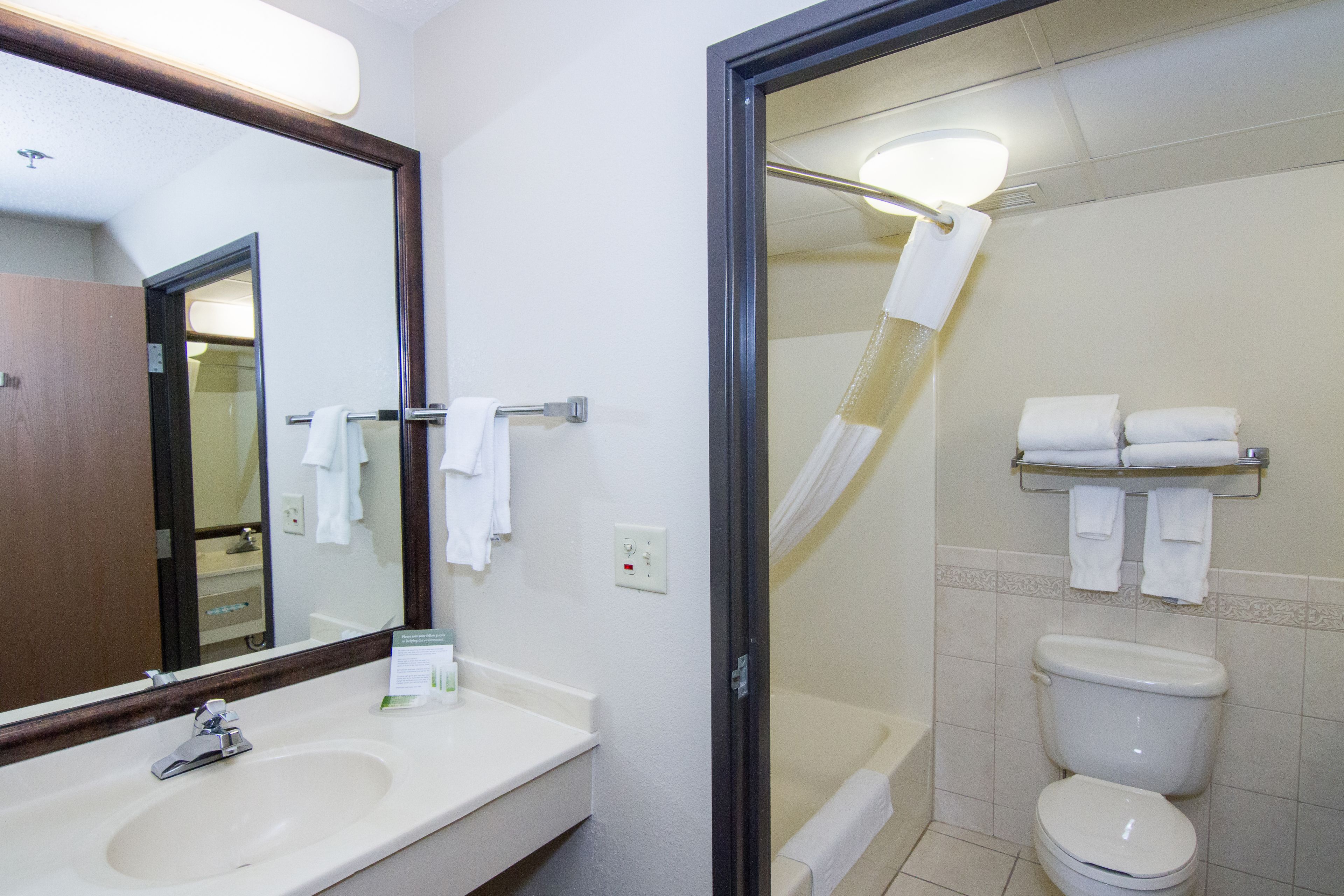 Un baño con lavamanos, espejo y retrete.