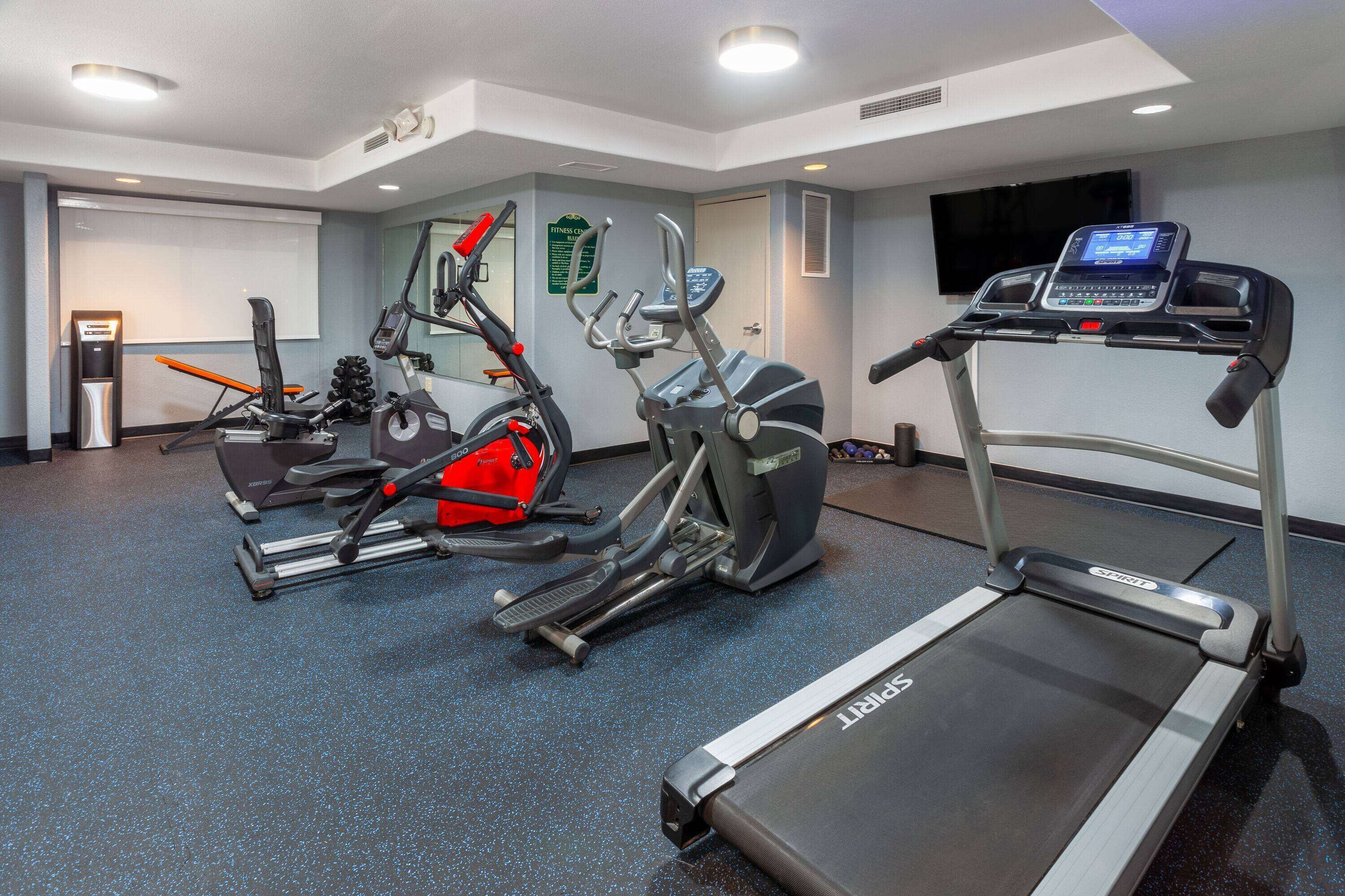 Un centre de remise en forme équipé de tapis de course, de vélos d’appartement et d’appareils elliptiques.