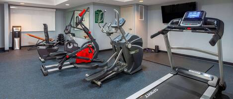 Un centre de remise en forme équipé de tapis de course, de vélos d’appartement et d’appareils elliptiques.