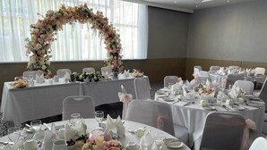 A banquet hall with round tables set for a formal event, complete with floral centerpieces and white tablecloths. - Kings Park Hotel (Glasgow)