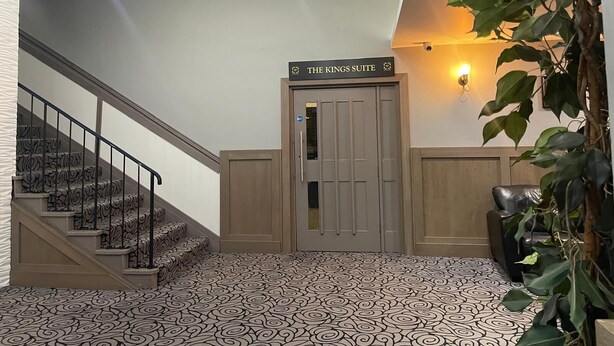 A hotel entrance with a staircase leading to a room labeled "The Kings Suite." - Kings Park Hotel (Glasgow)