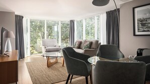 Una sala de estar moderna con un sofá, sillones, una mesa de centro y una lámpara.