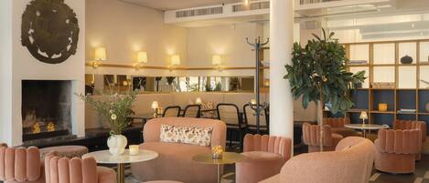 A modern lounge area with plush seating, a fireplace, and ambient lighting.